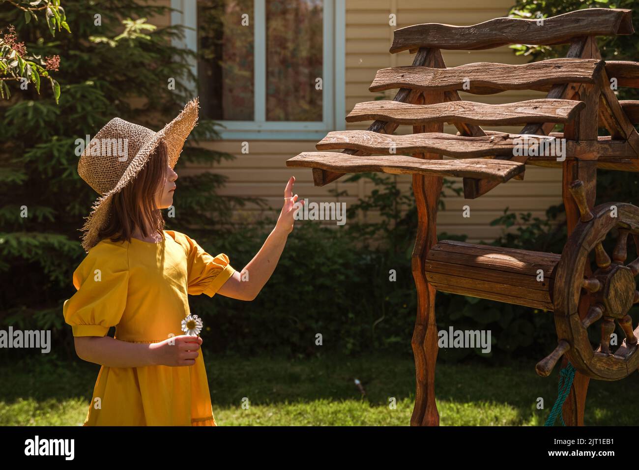 cute little girl in a yellow dress and straw hat walking Stock Photo ...