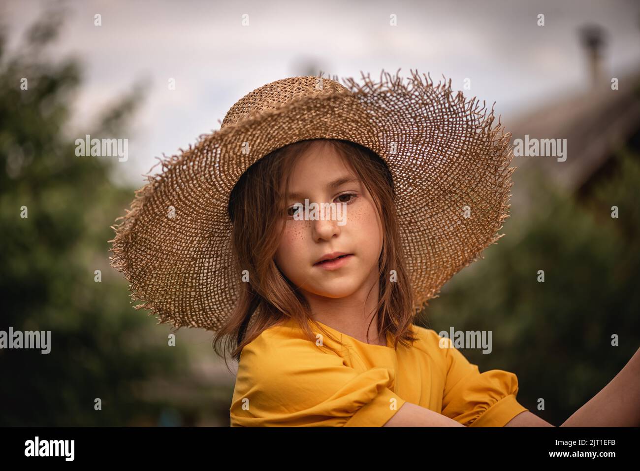 cute little girl in a yellow dress and straw hat walking through the ...