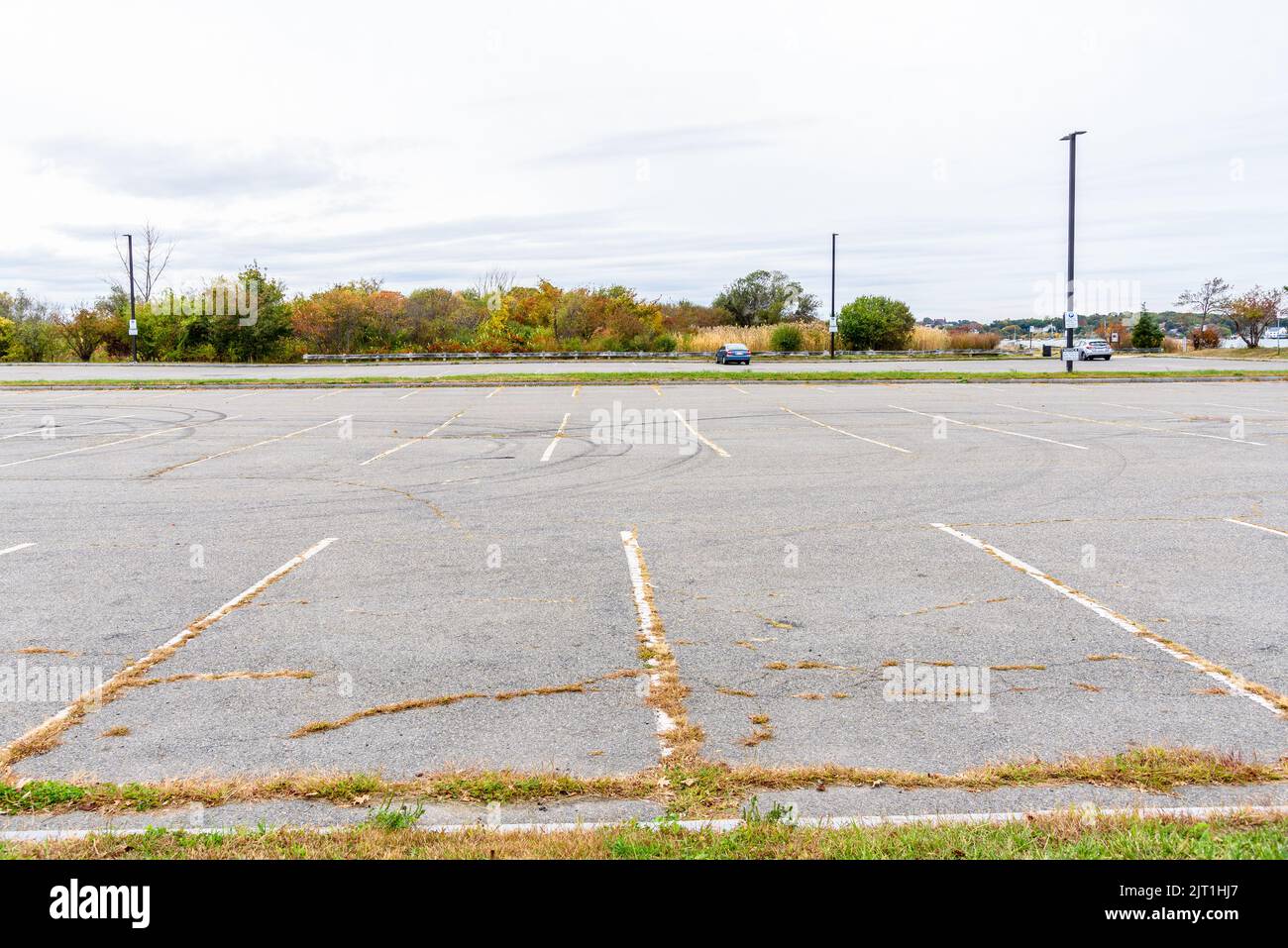 Old almost empty parking lot under cloudy sky in autumn Stock Photo