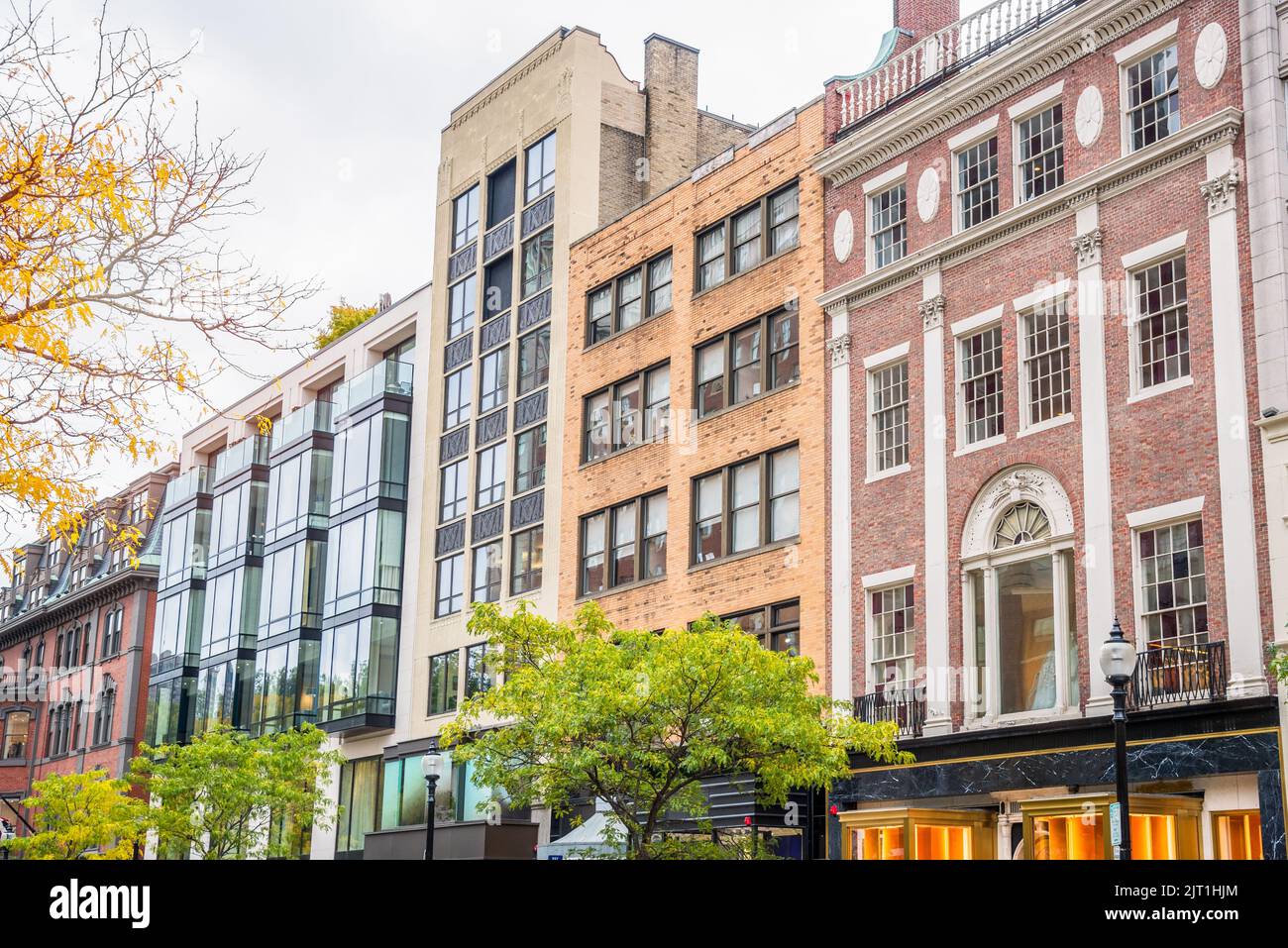 Row of traditional buildings with shops on ground level in a downtown shopping district on a cloudy autumn day Stock Photo