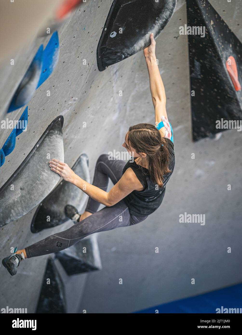 The young fitness woman doing professional bouldering at indoor gym