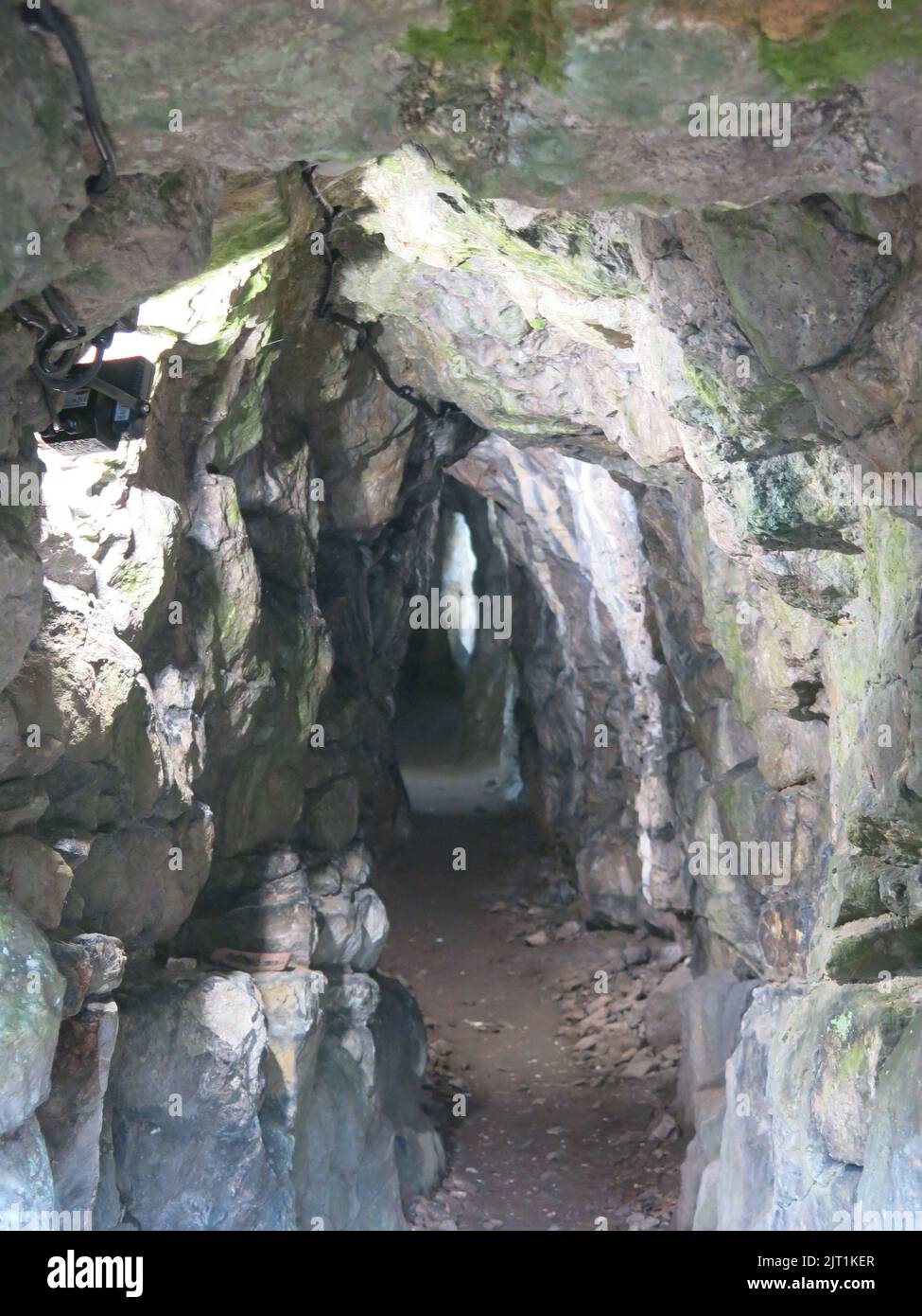 View inside the adit, or horizontal rock tunnel, which visitors can walk through for some distance at the Old Lead Mine, Cascades Gardens, Derbyshire. Stock Photo