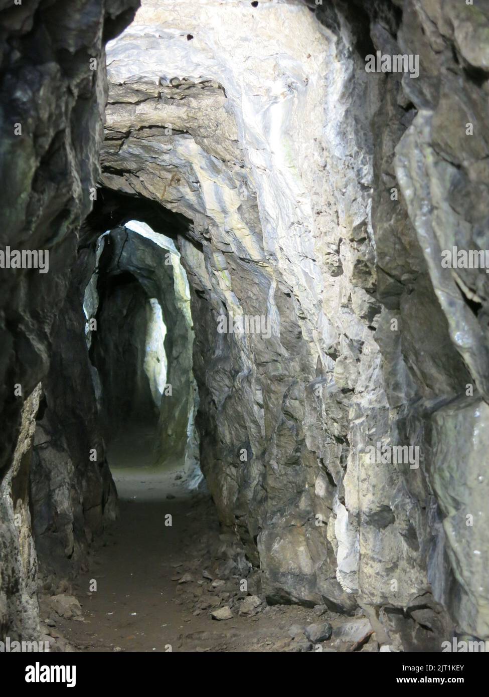 View inside the adit, or horizontal rock tunnel, which visitors can walk through for some distance at the Old Lead Mine, Cascades Gardens, Derbyshire. Stock Photo