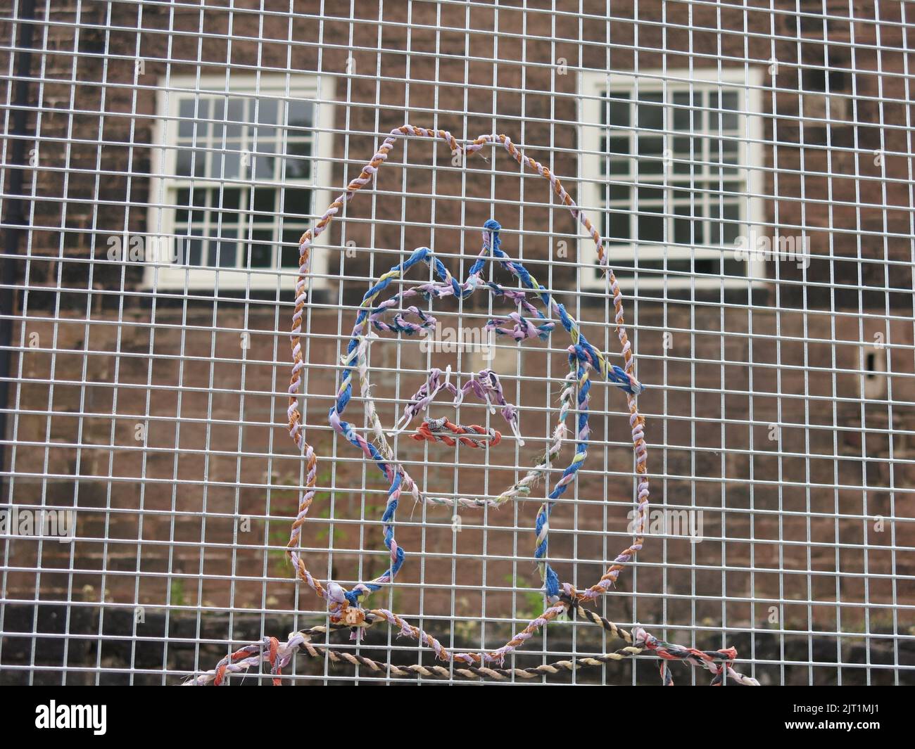 'Cotton Labour': art installation by Hetain Patel, symbolic portraits woven with yarn into a mesh structure against a backdrop of Cromford Mills. Stock Photo