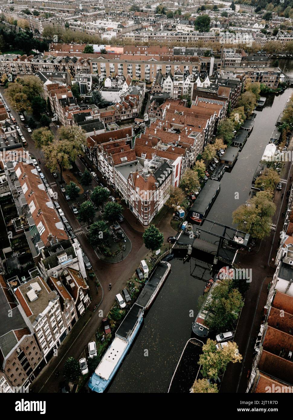 An aerial view of boats on canal surrounded by buildings in Amsterdam