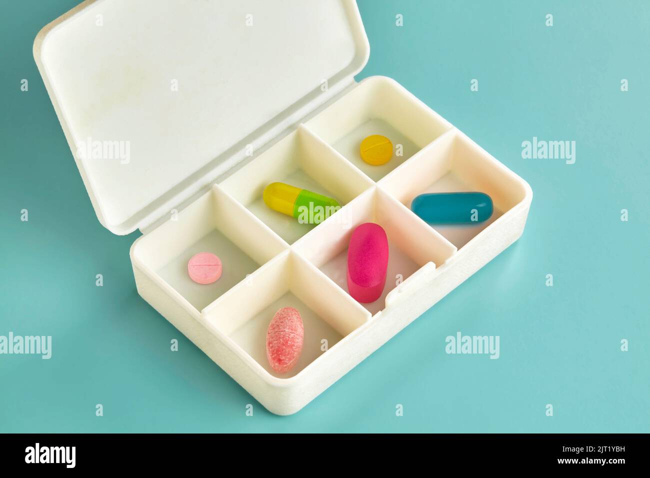 Six different colours and shapes of medicine in a daily pill medicine box Stock Photo