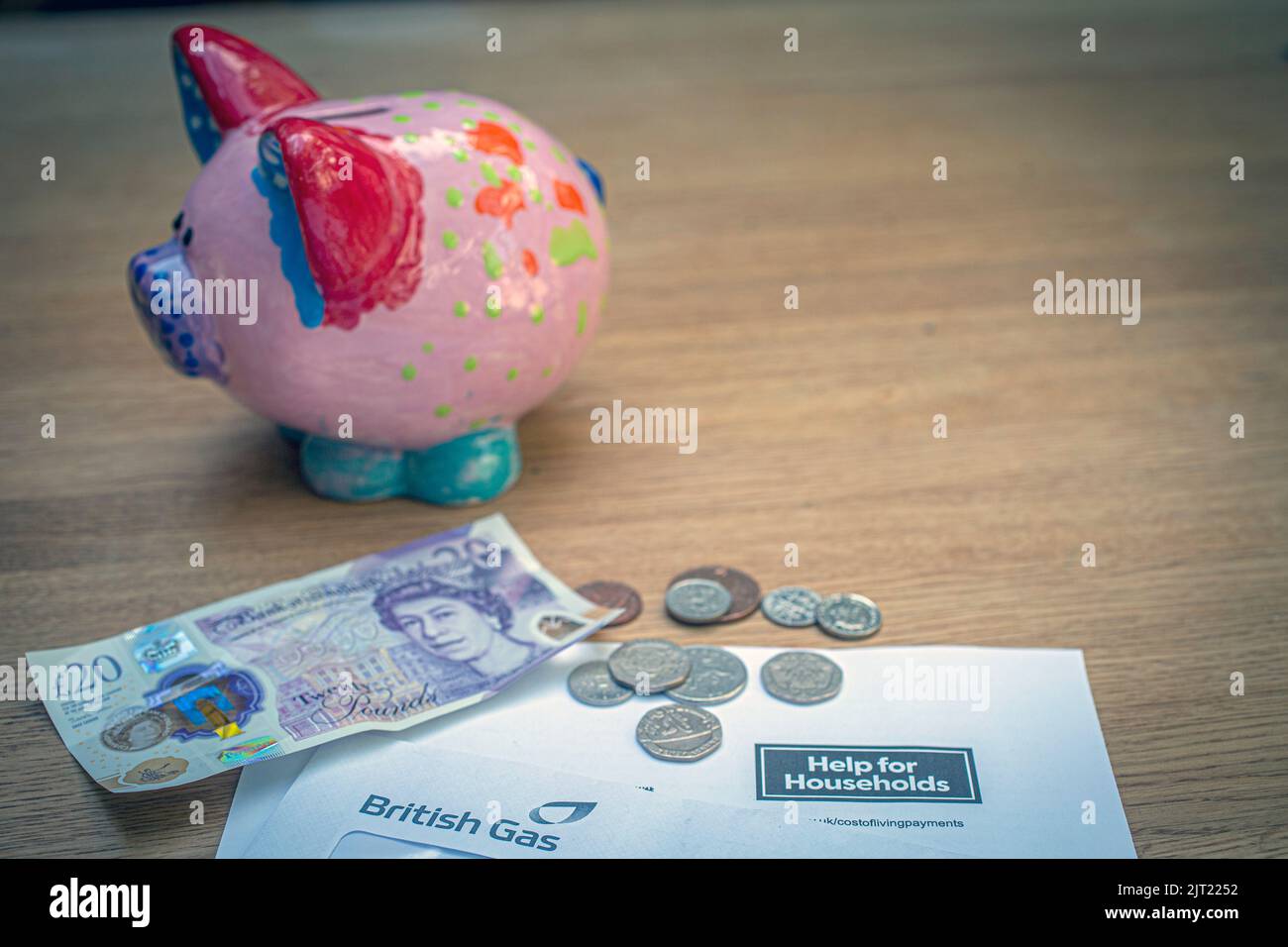 British £20 note and coins on HM Government letter notifying of UK government household help, United Kingdom Stock Photo