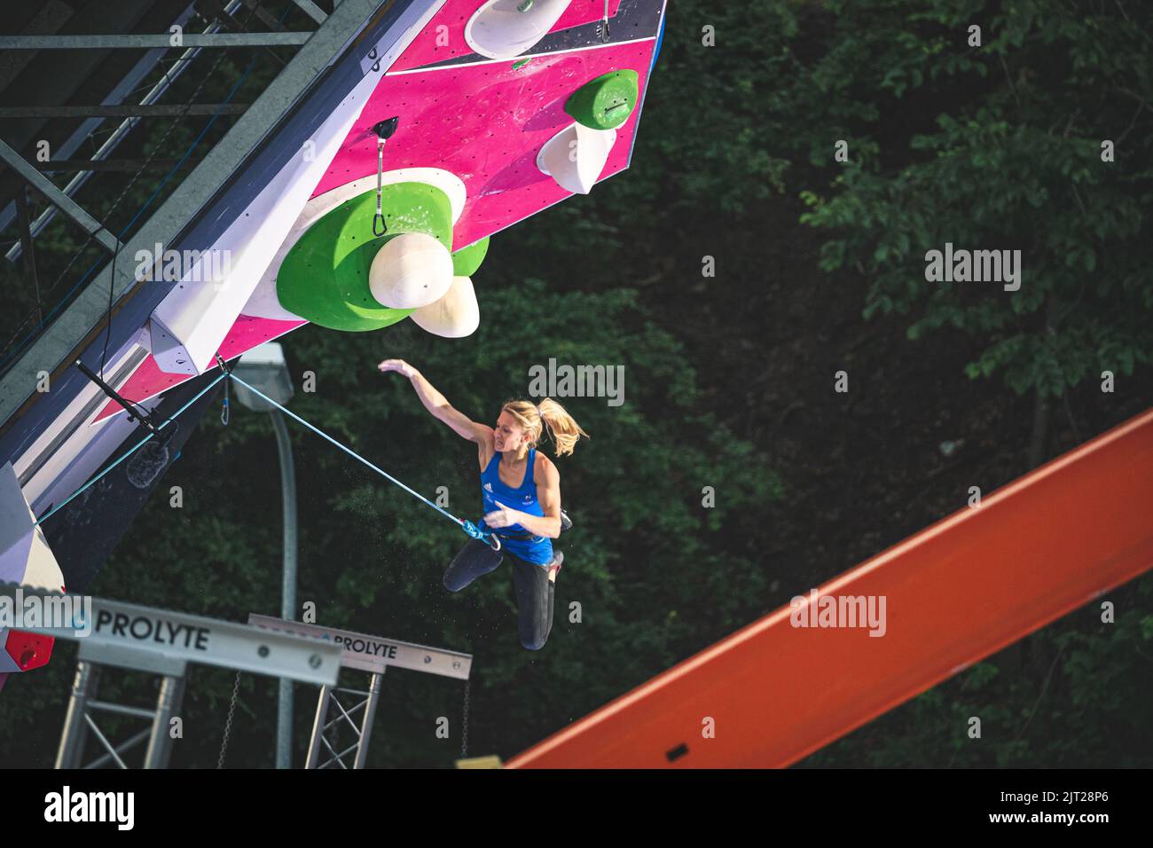 An athlete jumping on the final route of the IFSC lead world cup Stock