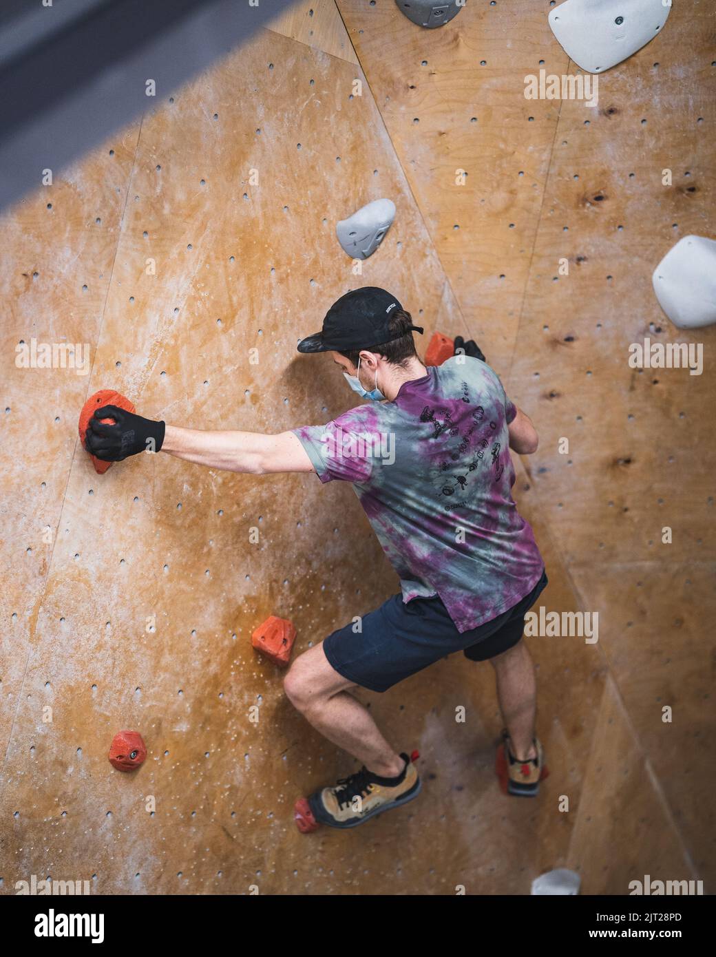 A climbing route setter trying to set a route in the bouldering gym