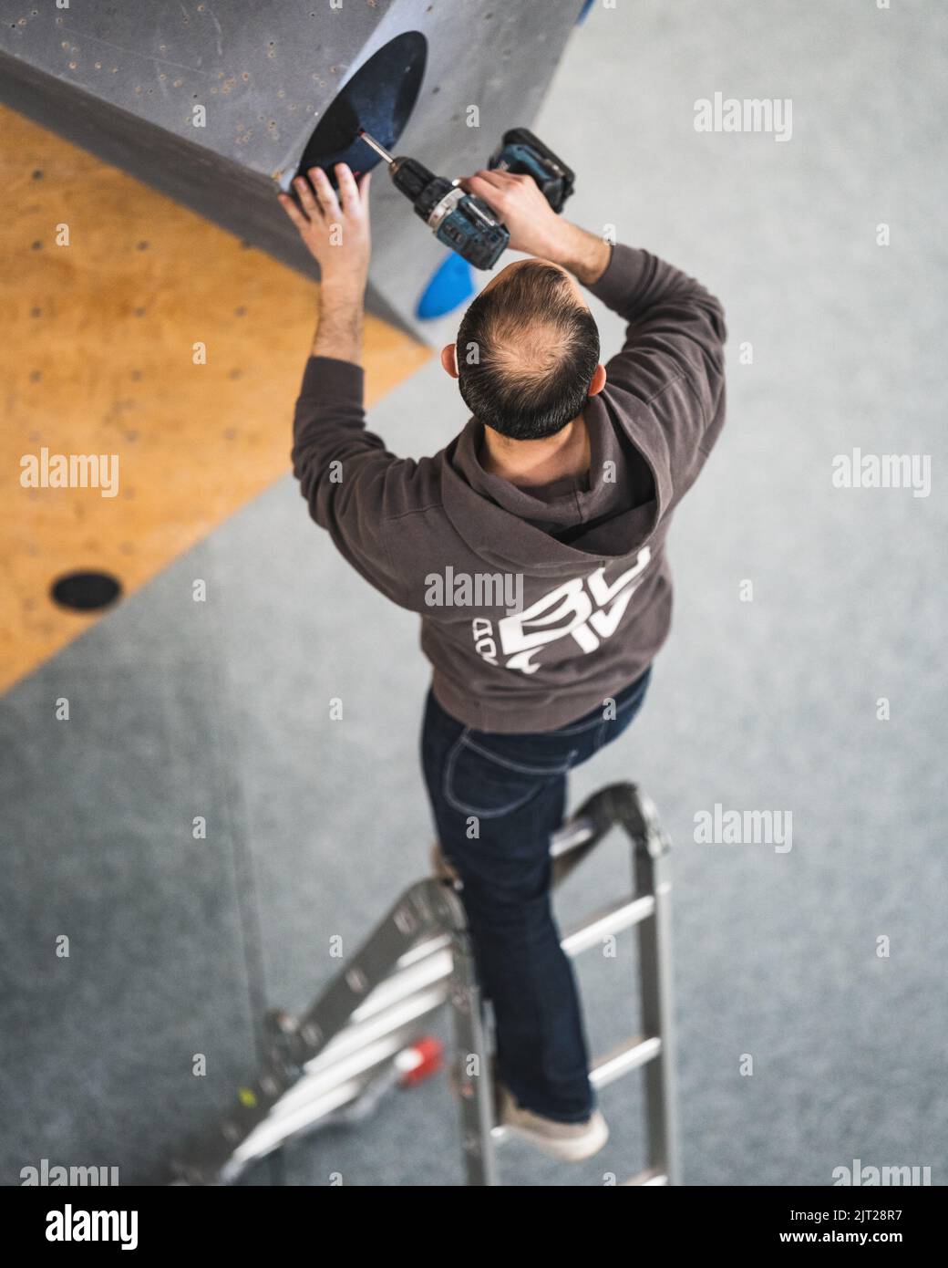 A climbing route setter trying to set a route in the bouldering gym
