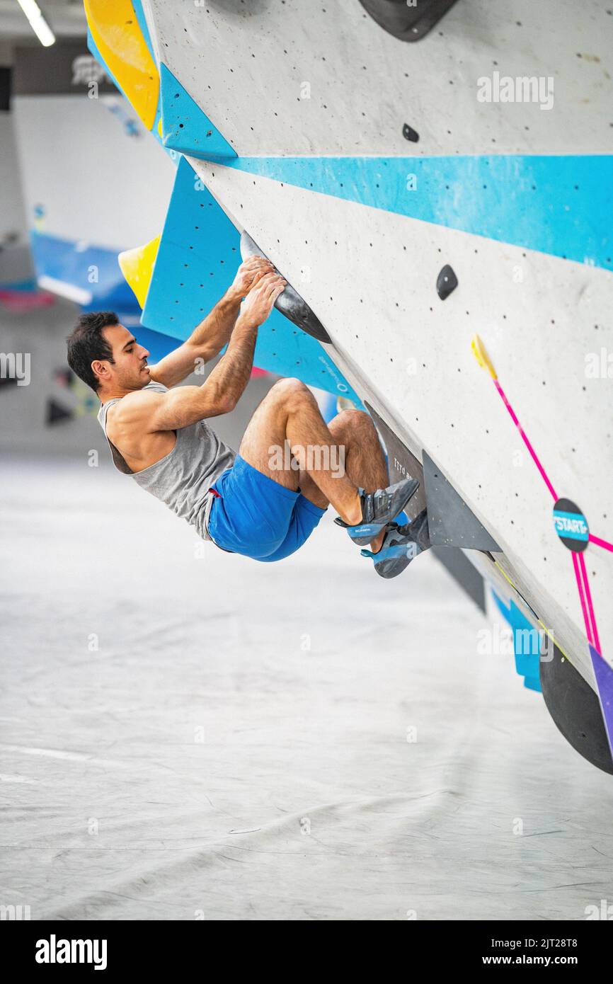 A climbing route setter trying to set a route in the bouldering gym