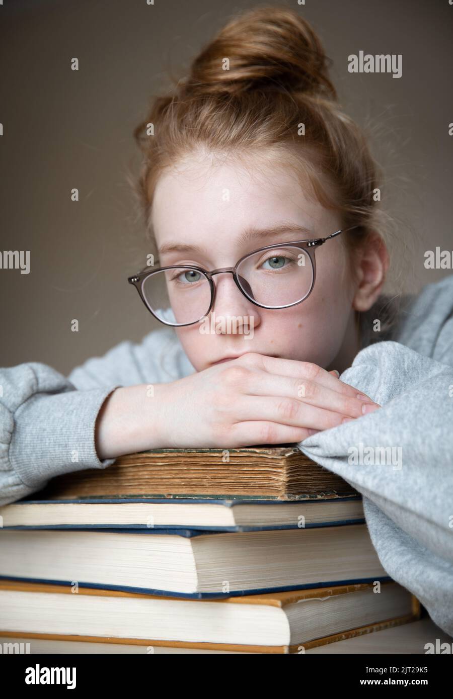 Portrait of a red-haired teenage girl with glasses. Stock Photo