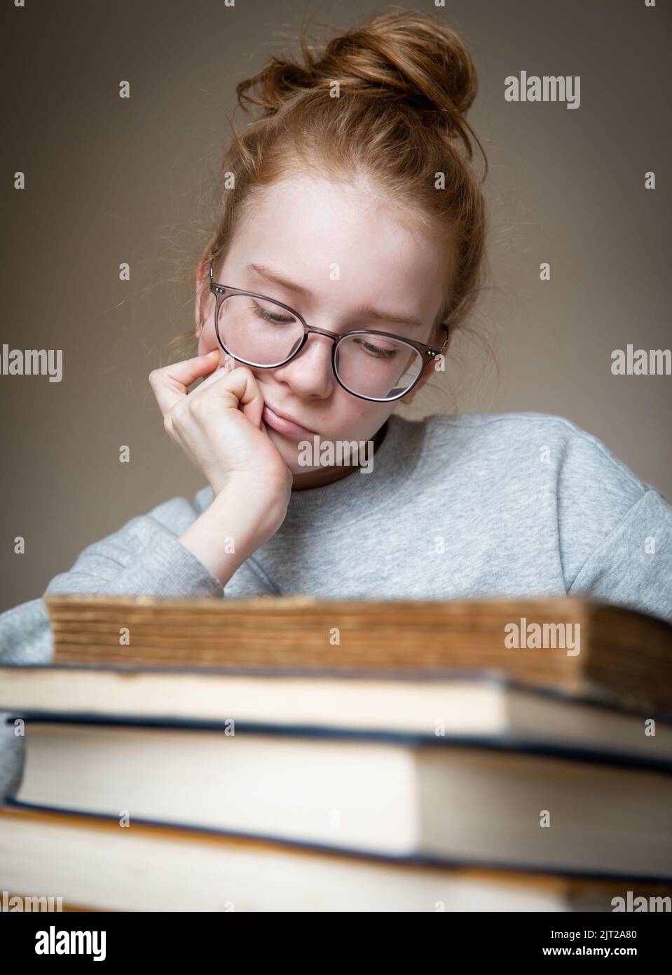Portrait of a red-haired teenage girl with books. Stock Photo