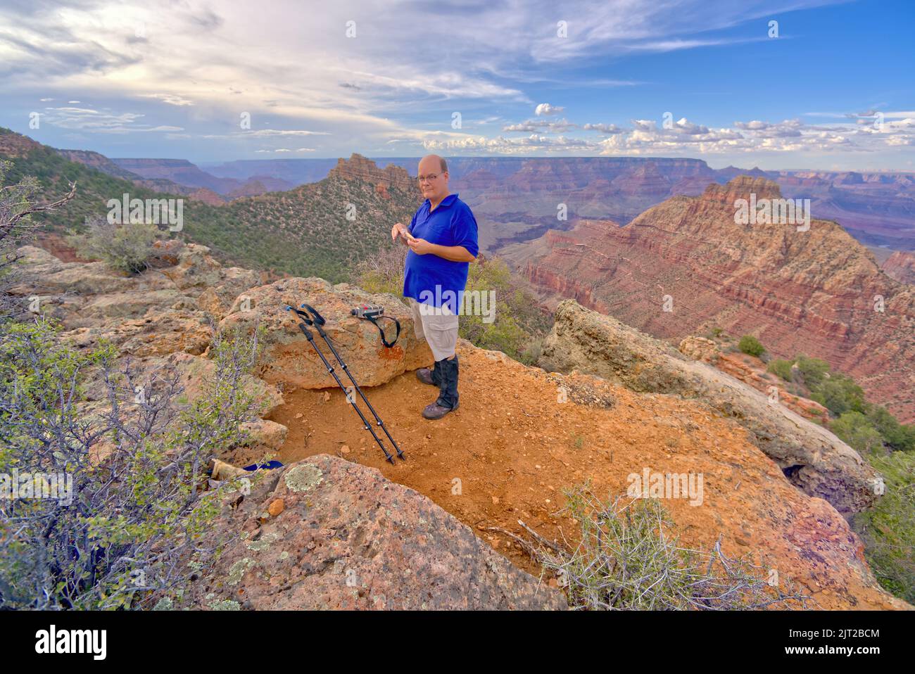 A hiker preparing to eat lunch while on Buggeln Hill at Grand Canyon Arizona. Stock Photo
