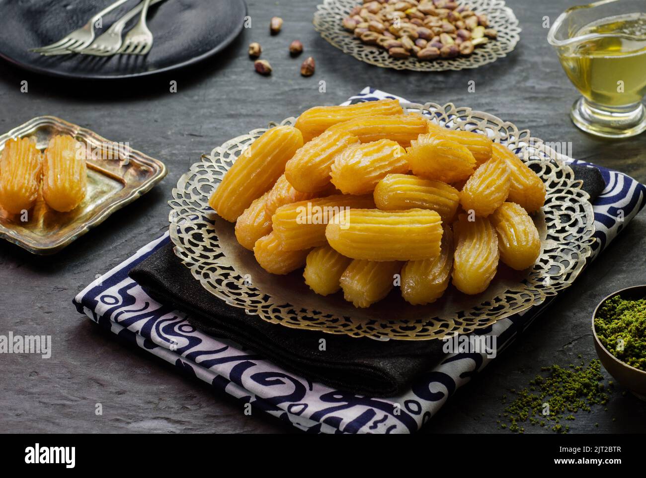 Arabic Cuisine: Middle Eastern Traditional dessert/Ramadan dessert Balah Al-Sham or Balah El Shaam served with pistachio and  honey syrup. Stock Photo