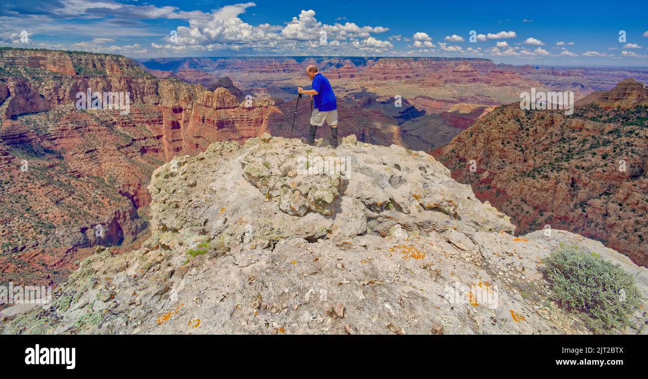 A hiker on the edge of a cliff halfway between Grandview Point and the Sinking Ship at Grand Canyon Arizona. Stock Photo