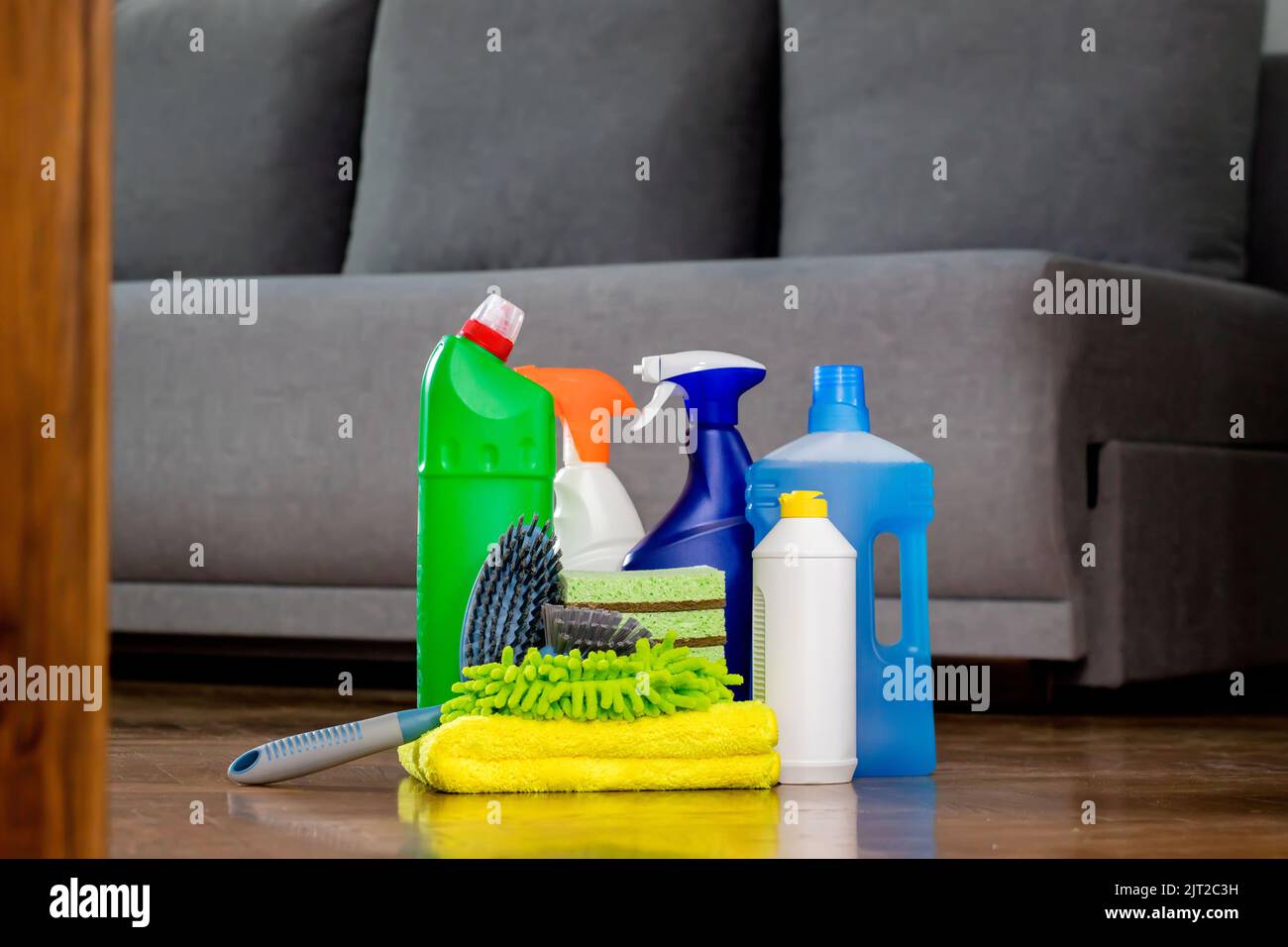 Household cleaning products and rags on floor. Chemical liquids for