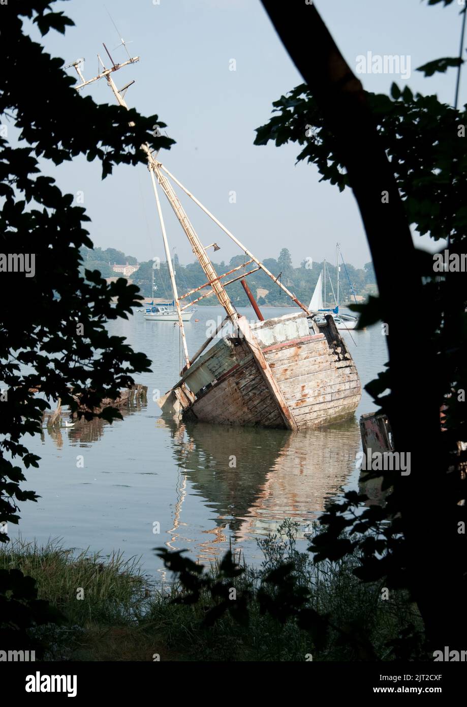 Ruined Boat on the River Orwell at Pin Mill, Suffolk, UK. Badly damaged