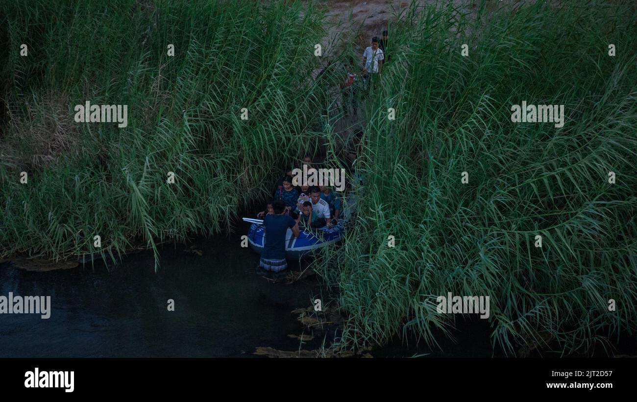 Asylum seeking migrants enter a raft before being smuggled from the bank of the Rio Grande river into the United States, from Ciudad Miguel Aleman, Mexico August 26, 2022. REUTERS/Adrees Latif Stock Photo