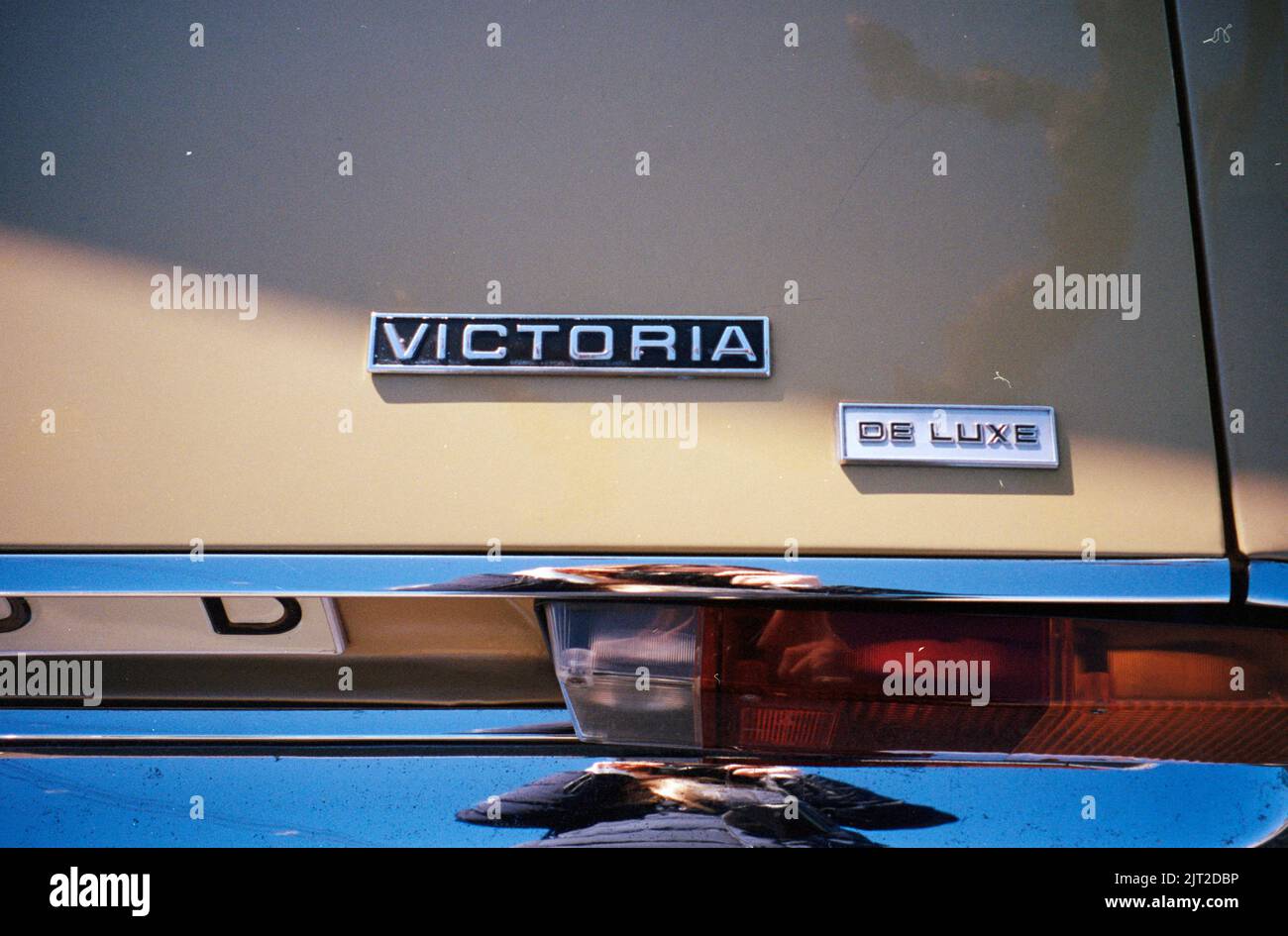 A closeup of the logo, tail lights, and plat numbers of an old Austin Victoria De Luxe car in cream color Stock Photo