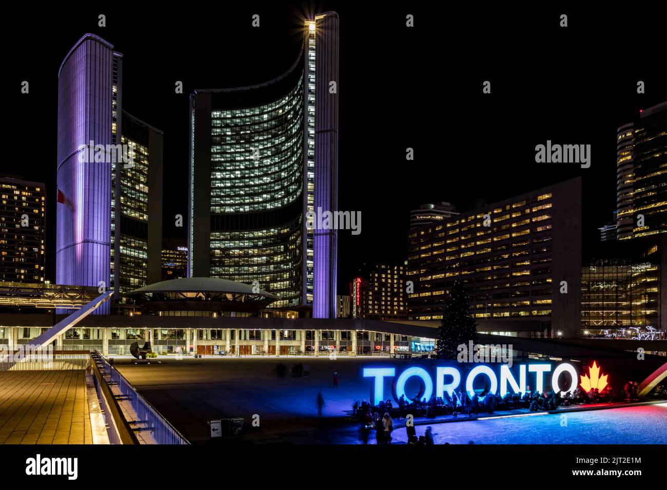 The iconic saucer and curved towers of Toronto City Hall, where skaters gather on a cold January night in Nathan Phillips Square. Stock Photo