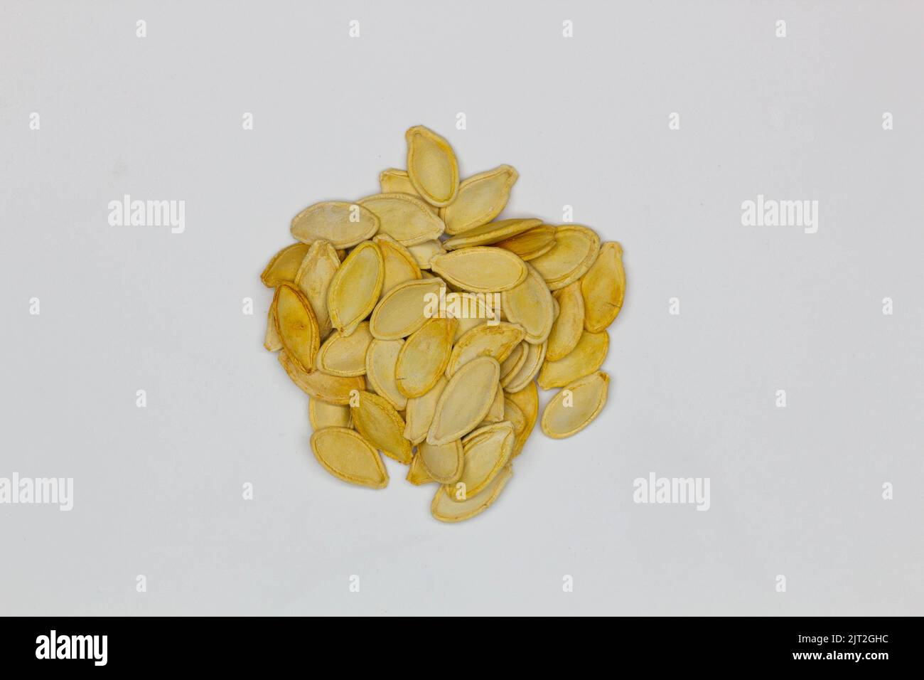Dried pumpkin seeds in husks. Yellow pumpkin seeds on a white