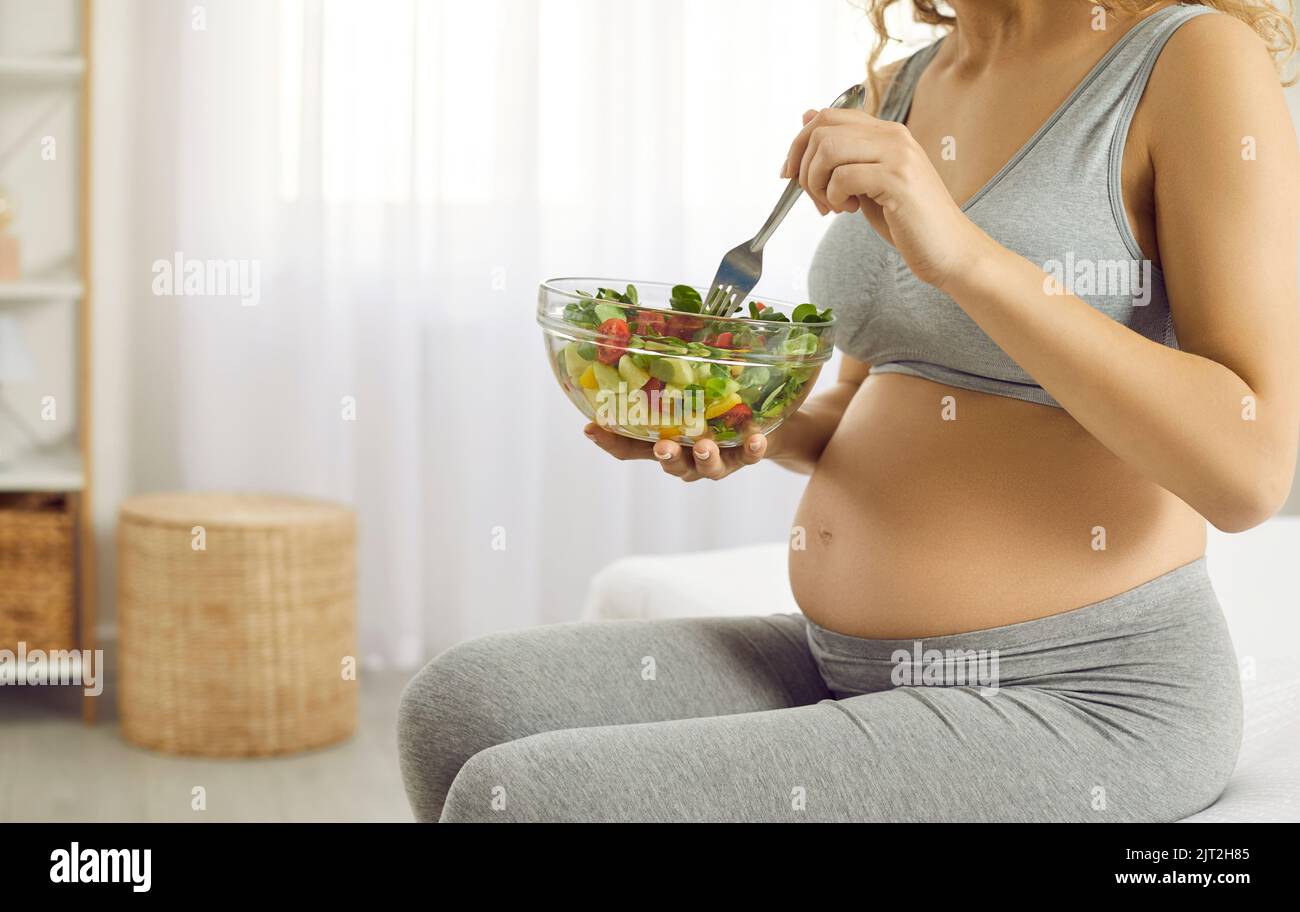 Young expectant mother takes care of her health and eats lots of fresh vegetables Stock Photo
