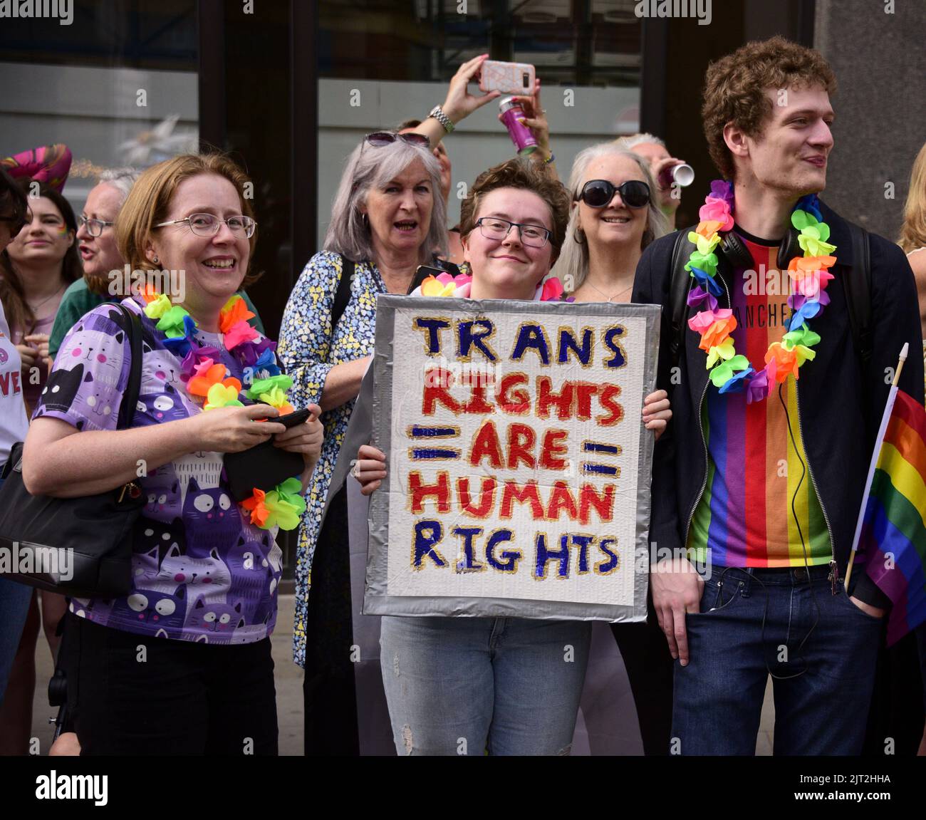 Manchester, UK. 27th August, 2022. A person carries a placard: 'Trans rights are human rights'.  Participants take part in the LGBTQ+ Pride parade, central Manchester, UK, as LGBTQ+ Pride continues over the Bank Holiday weekend 26th to 29th August. Organisers say: 'Manchester Pride is one of the UK's leading LGBTQ+ charities. Our vision is a world where LGBTQ+ people are free to live and love without prejudice. We’re part of a global Pride movement celebrating LGBTQ+ equality and challenging discrimination.' Credit: Terry Waller/Alamy Live News Stock Photo