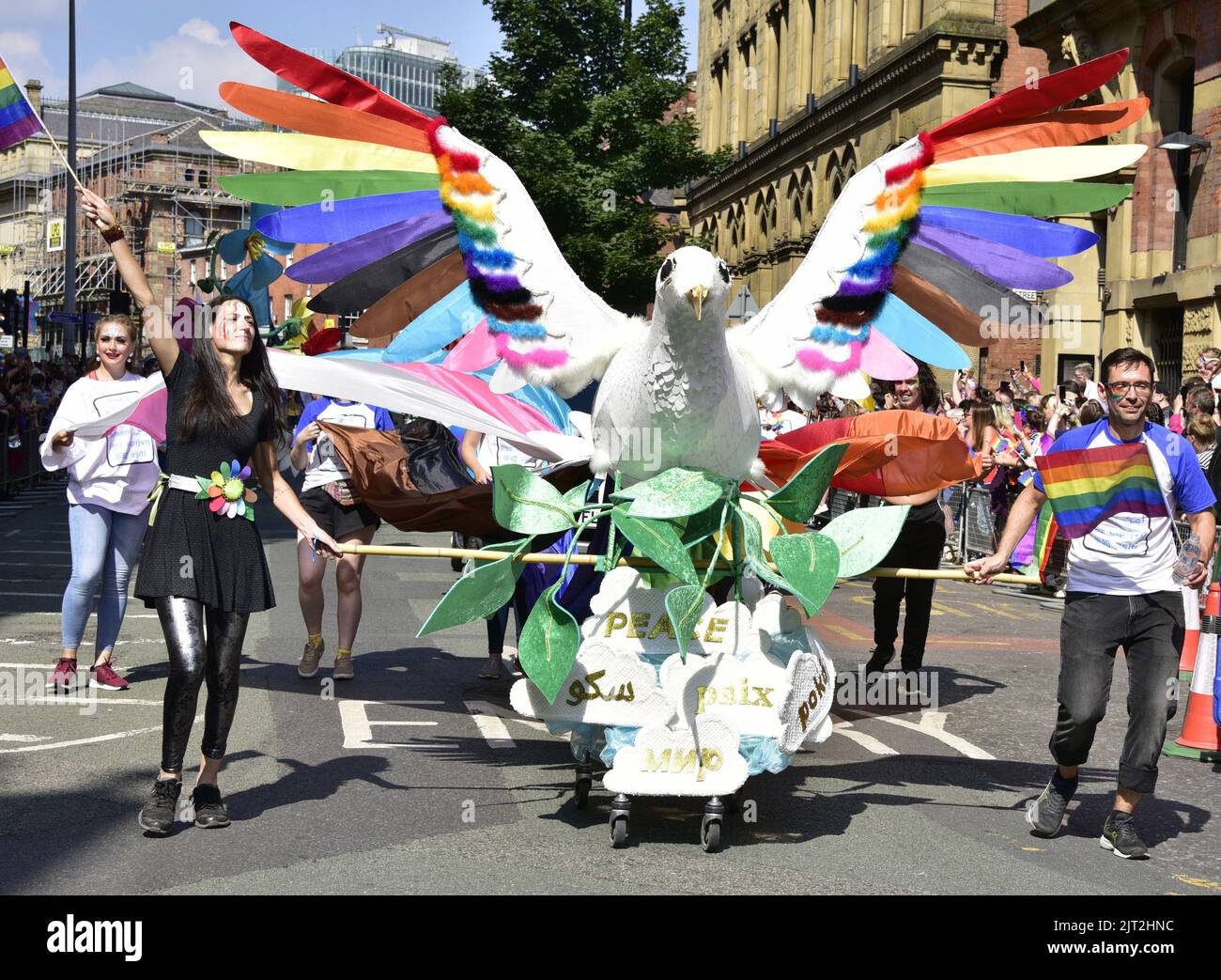 Manchester, UK. 27th August, 2022. A peace float with rainbow and trans flags leads the parade. Participants take part in the LGBTQ+ Pride parade, central Manchester, UK, as LGBTQ+ Pride continues over the Bank Holiday weekend 26th to 29th August. Organisers say: 'Manchester Pride is one of the UK's leading LGBTQ+ charities. Our vision is a world where LGBTQ+ people are free to live and love without prejudice. We’re part of a global Pride movement celebrating LGBTQ+ equality and challenging discrimination.' Credit: Terry Waller/Alamy Live News Stock Photo