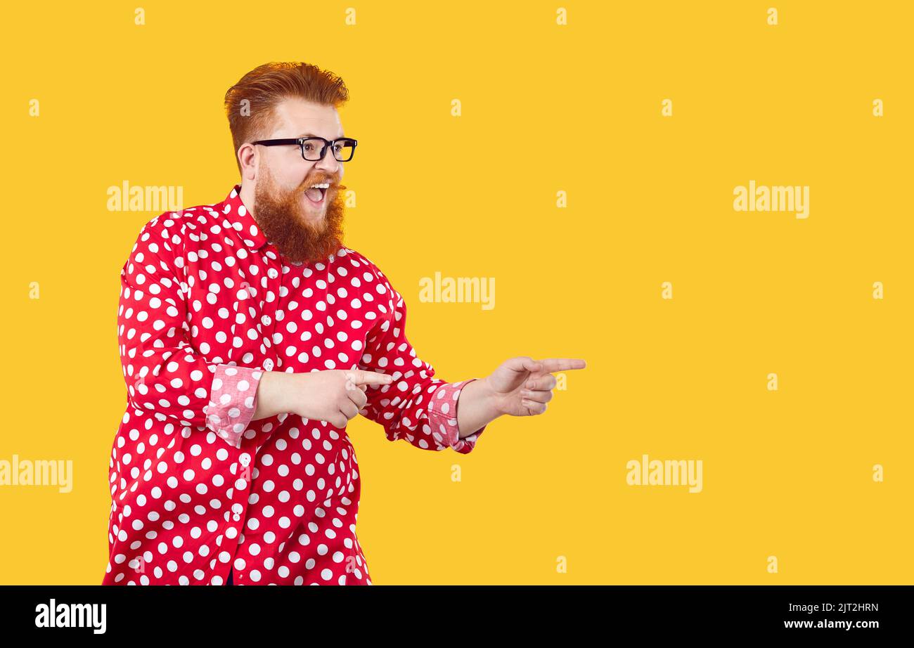Funny cheerful extravagant bearded fat man makes his choice showing on copy space. Stock Photo