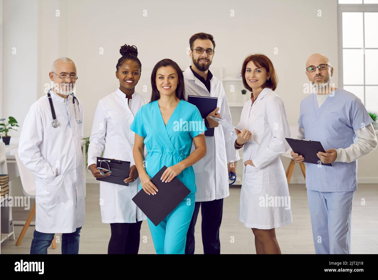 Diverse team of happy doctors and other medical workers at work at clinic or hospital Stock Photo