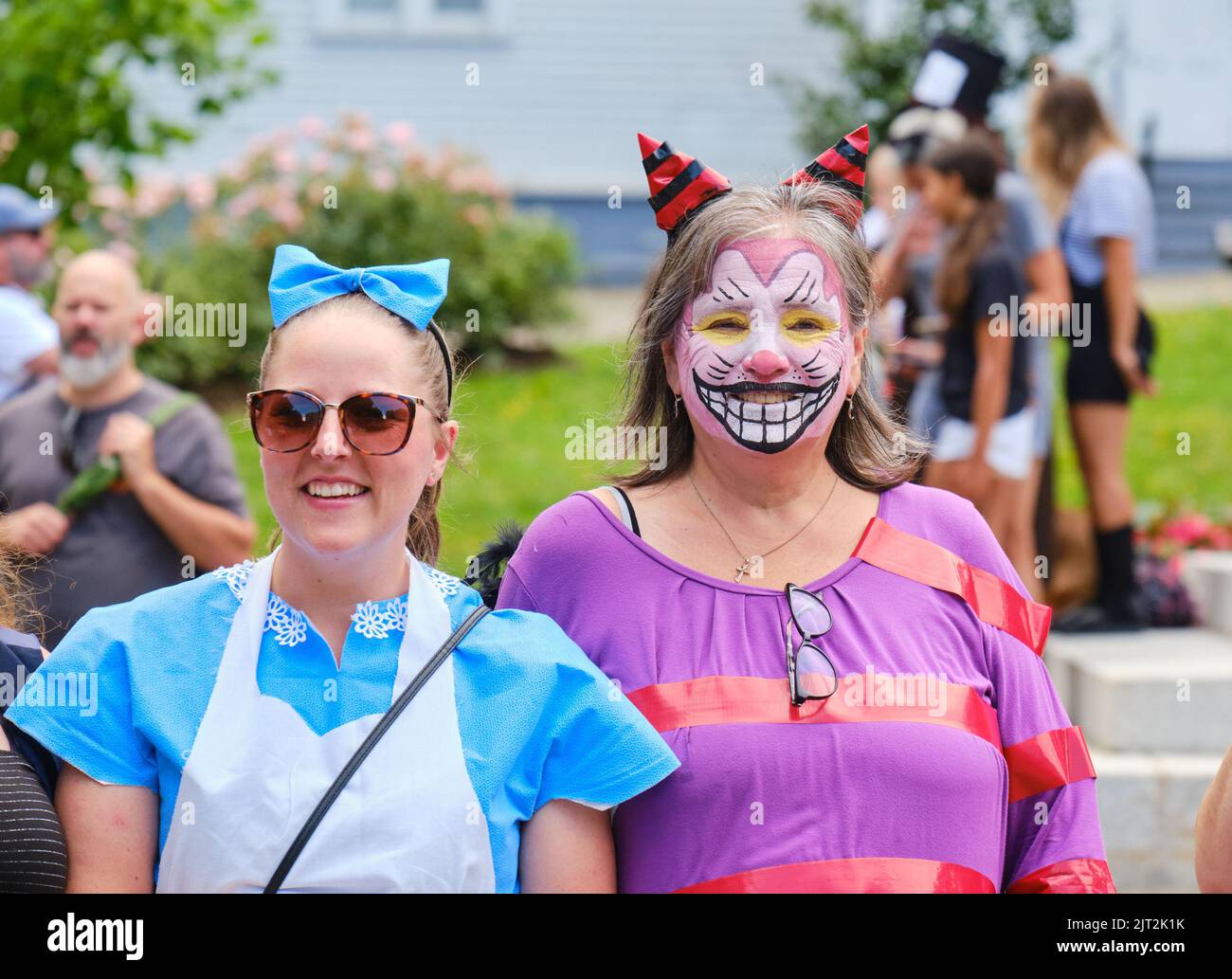 Halifax, Nova Scotia, Canada. August 27th, 2022. Alice and the Cheshire Cat still smiling as their team sets off through the streets of Halifax in search of the next clue in the Alice in Wonderland adventure. For one day only, the streets of Halifax are transformed into a giant, escape-room-style experience to find Alice in the App based adventure game. Credit: meanderingemu/Alamy Live News Stock Photo