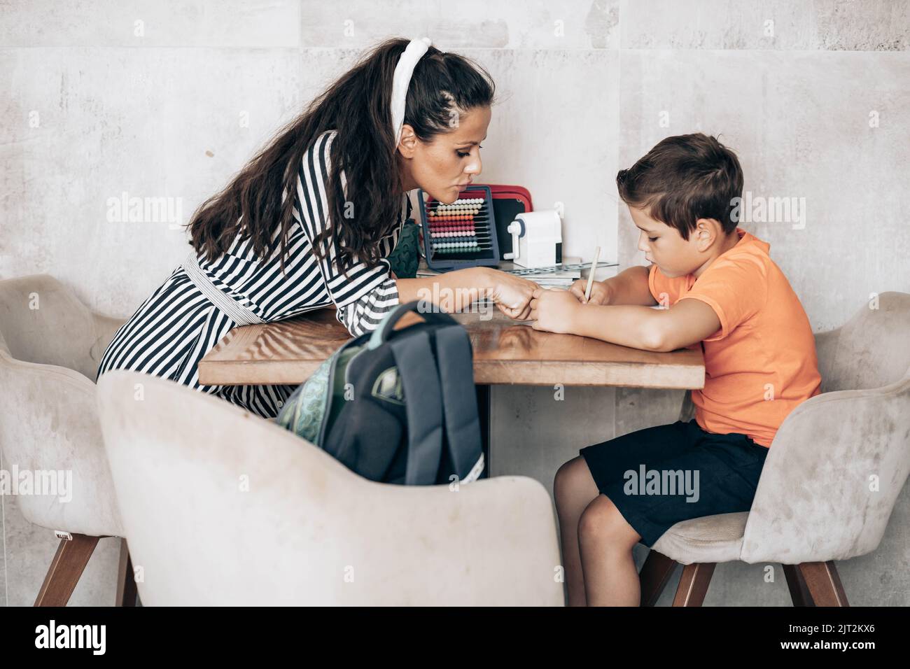 Little school boy doing homework with his mom helping him Stock Photo