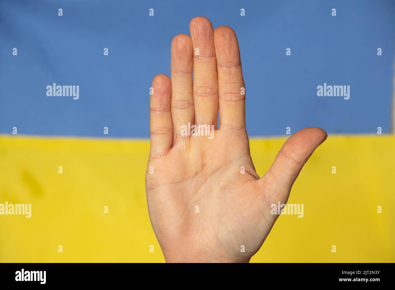 The flag of Ukraine is yellow-blue and the hand of a Ukrainian woman, Stop the war and patriotism, peace in Ukraine. Stop the war in Ukraine Stock Photo