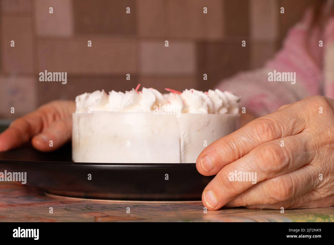 birthday cake on the table at home and mom's hands, holiday birthday, cake Stock Photo
