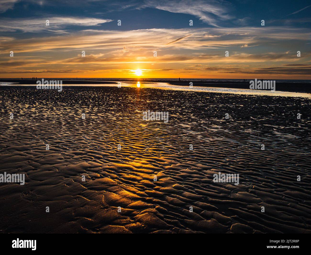 Ripples in the sand at low tide during dramatic sunset Stock Photo