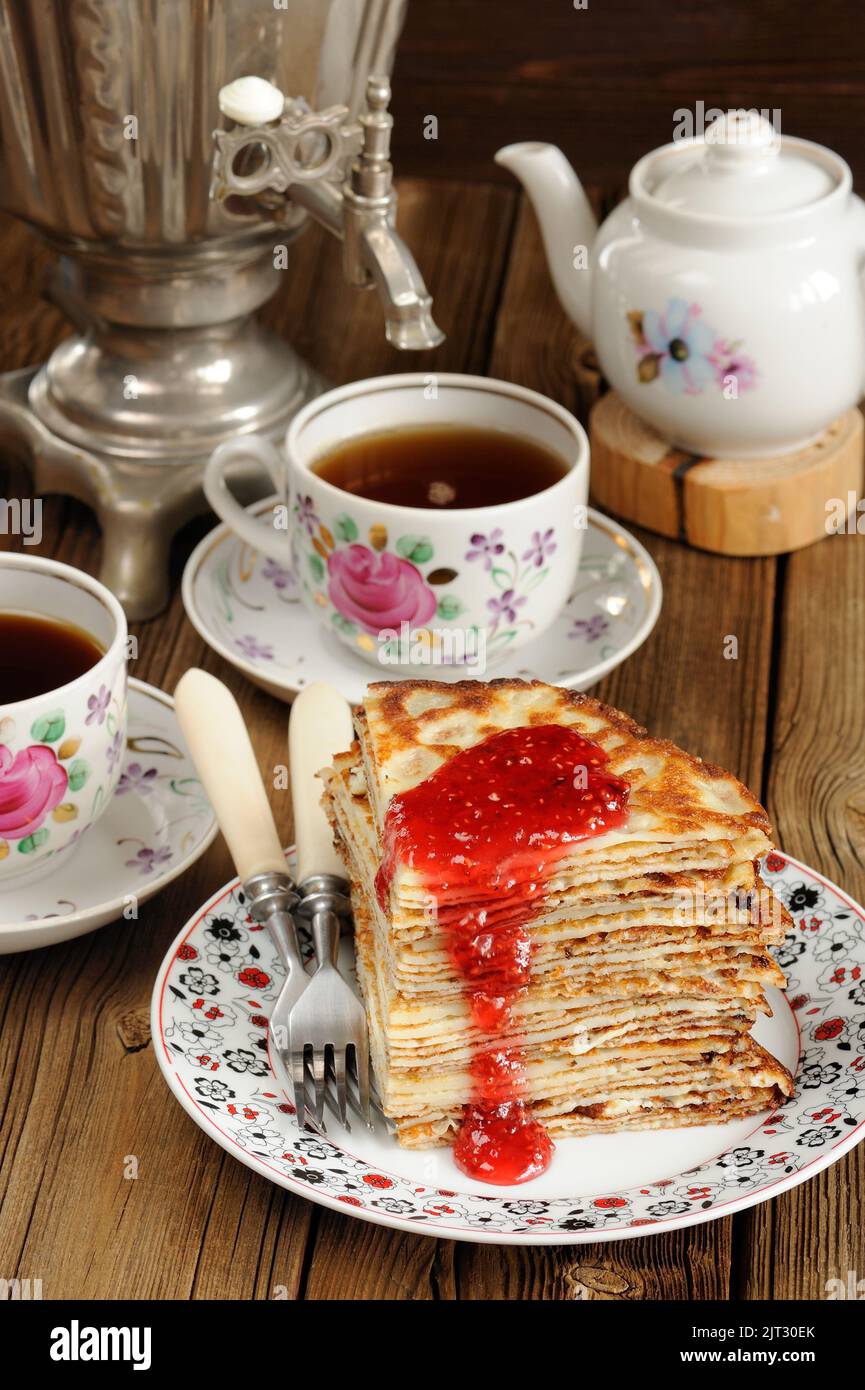 Russian bliny with raspberry jam, vintage samovar and teaware vertical ...