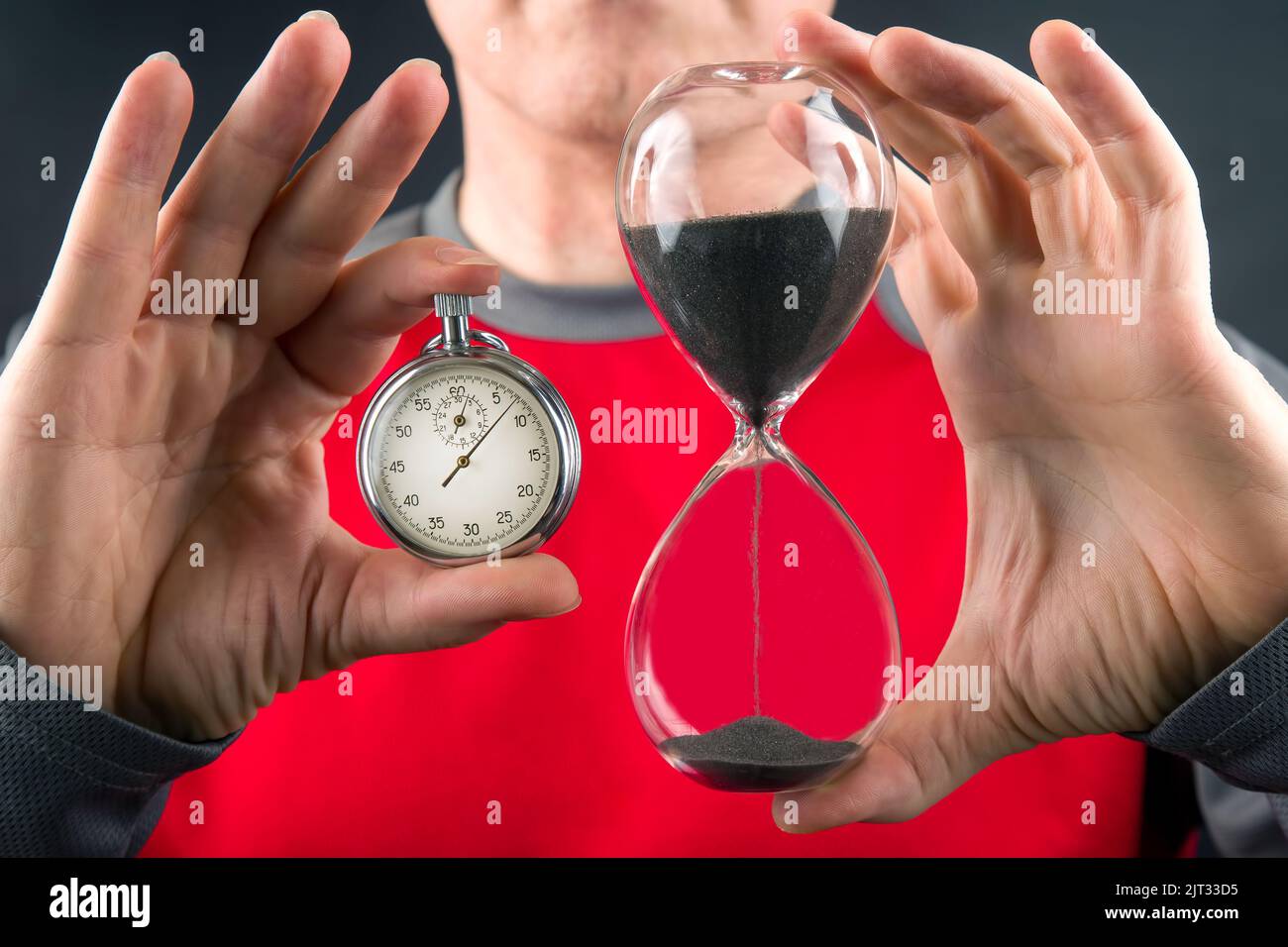 mechanical stopwatch and hourglass in hand. Time part precision. Measuring the speed interval