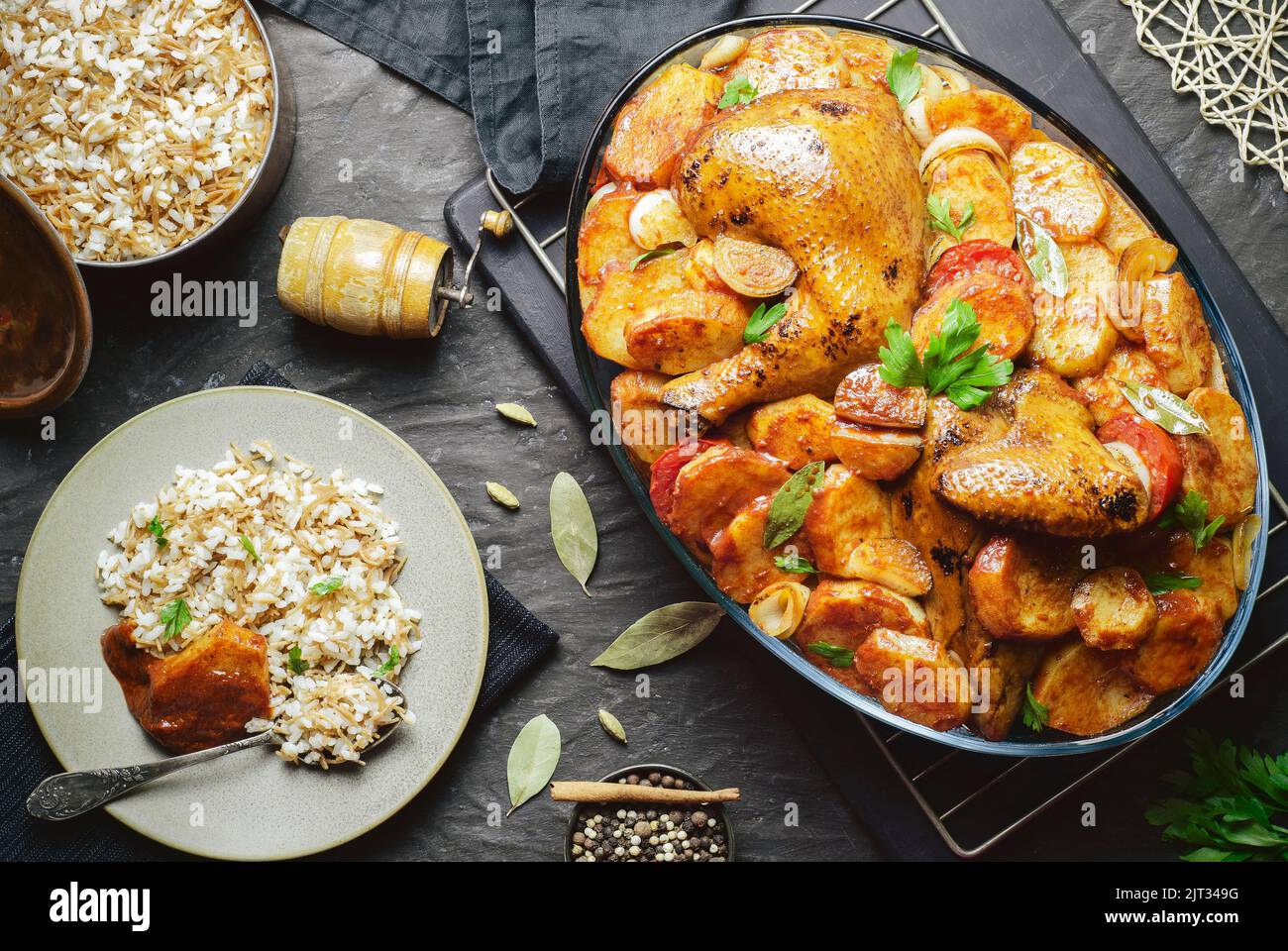 Arabic cuisine; Egyptian traditional dish 'Baked potatoes with roasted chicken' served with oriental rice with vermicelli. Top view with copy space. Stock Photo