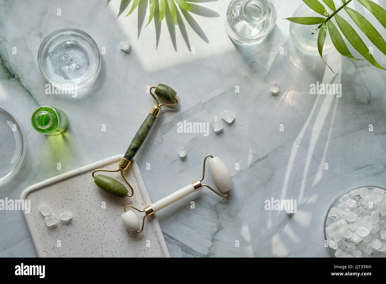 Home made moisturizer, green and white stone face rollers on off white