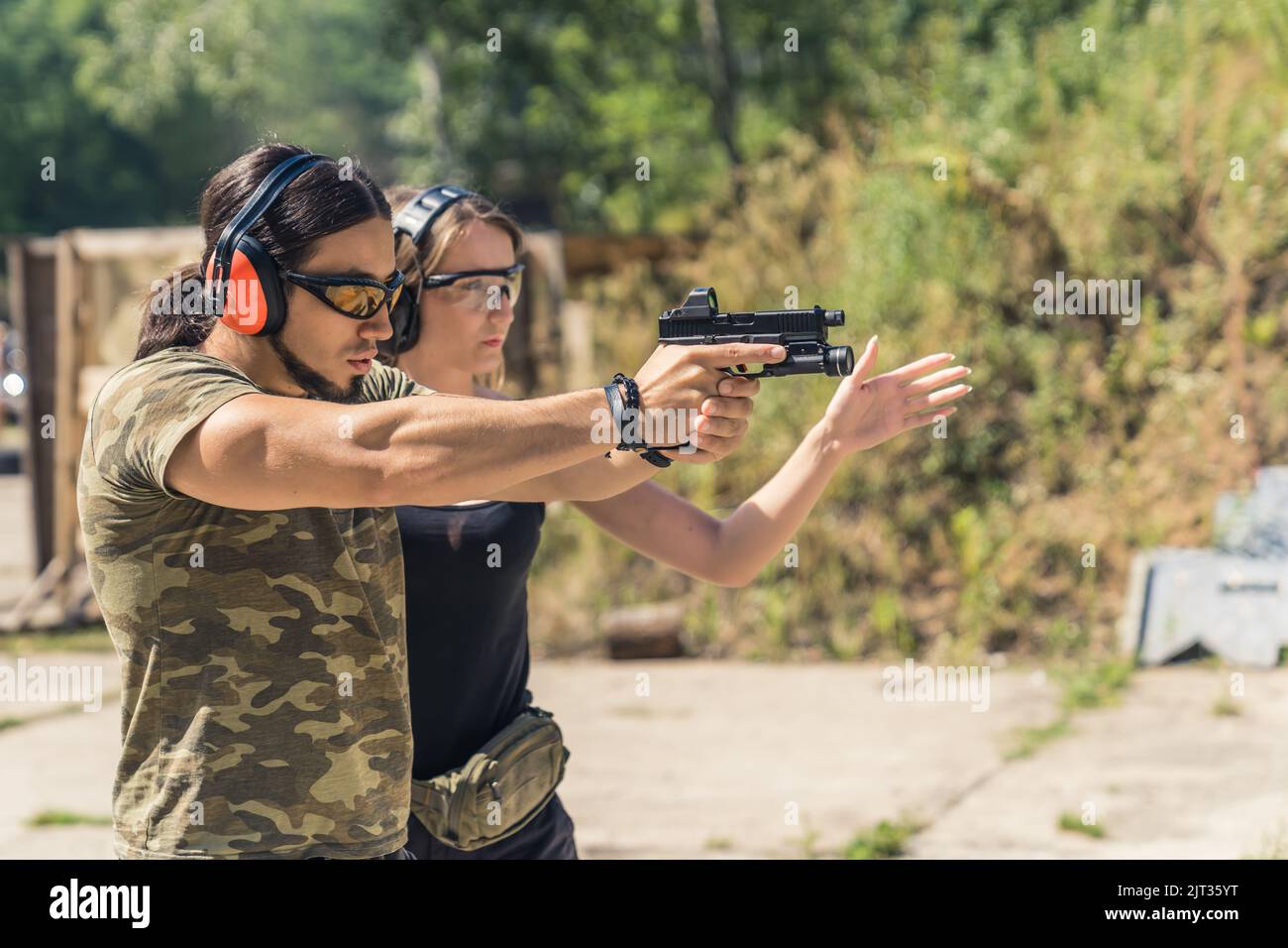 Safety first. Two caucasian people at a shooting range wearing