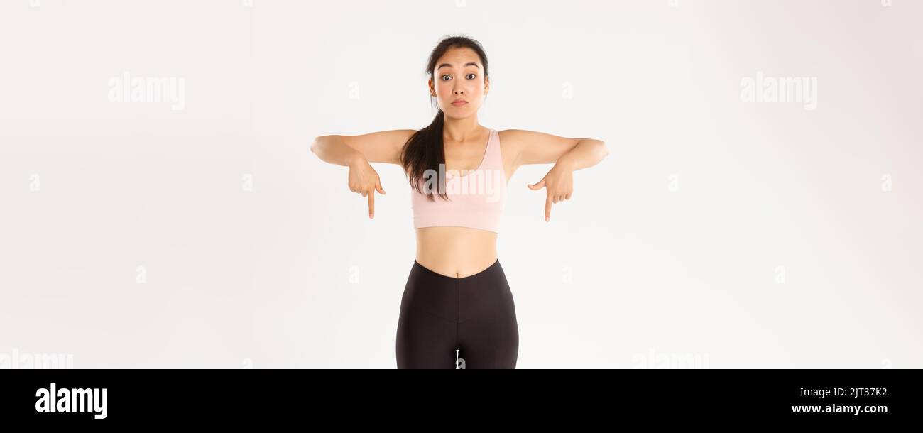 Sport, wellbeing and active lifestyle concept. Startled and impressed asian fitness girl, gym