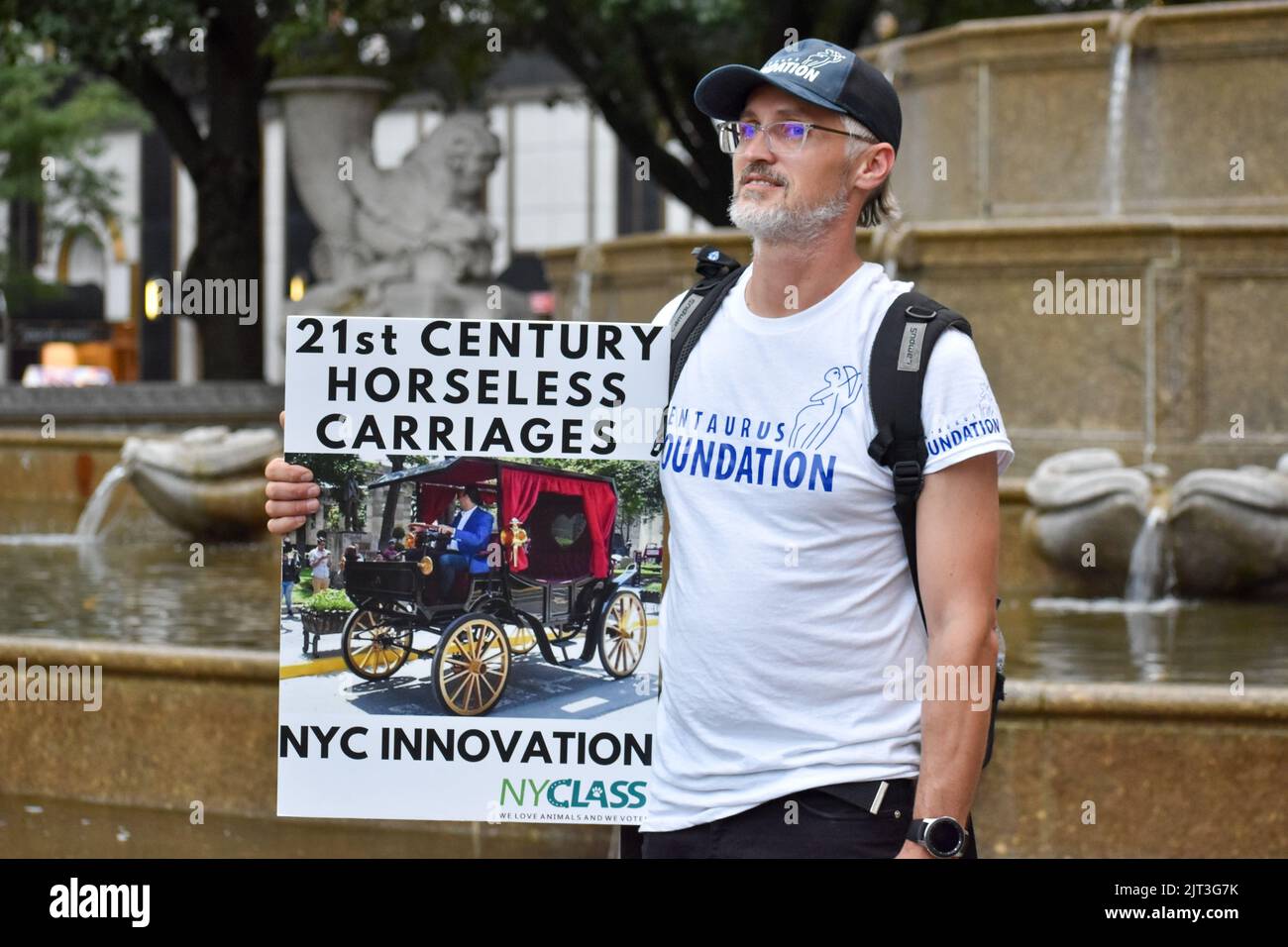 Rally participant is holding animal anti-abuse signs in front of the Pulitzer Fountain in Manhattan to demand end of horse carriage abuse in New York Stock Photo