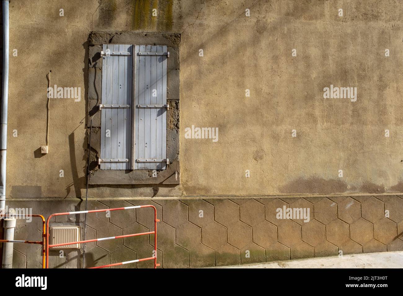 A typical window with grey shutters of the Southern France village of Tournissan, with no people, taken on a sunny end of winter day Stock Photo