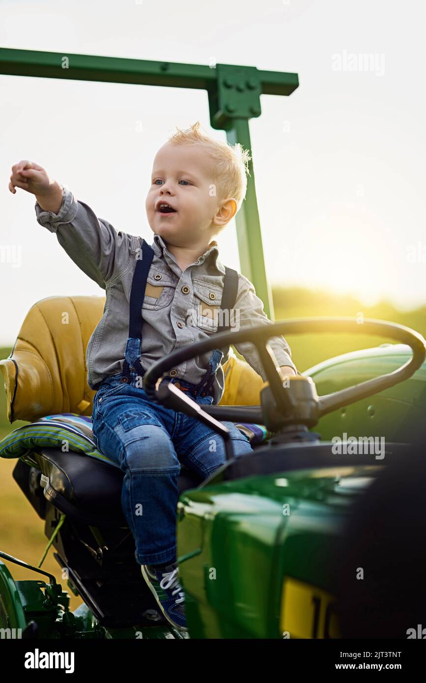Lets Go For A Trip On The Tractor An Adorable Little Boy Riding A Tractor On A Farm Stock Photo Lets Go For A Trip On The Tractor An Adorable Little Boy Riding A Tractor On A Farm Stock Photo
