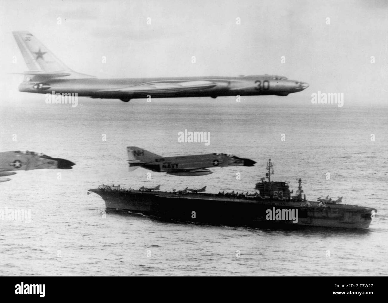Tu-16 flying over USS Kitty Hawk (CVA-63) 1963. Stock Photo