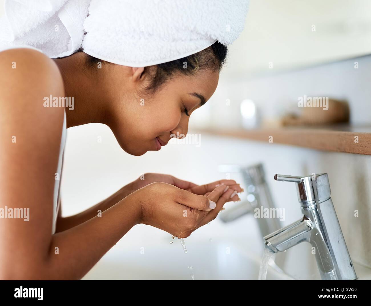 Remember to wash your face with clean water only. a young woman washing