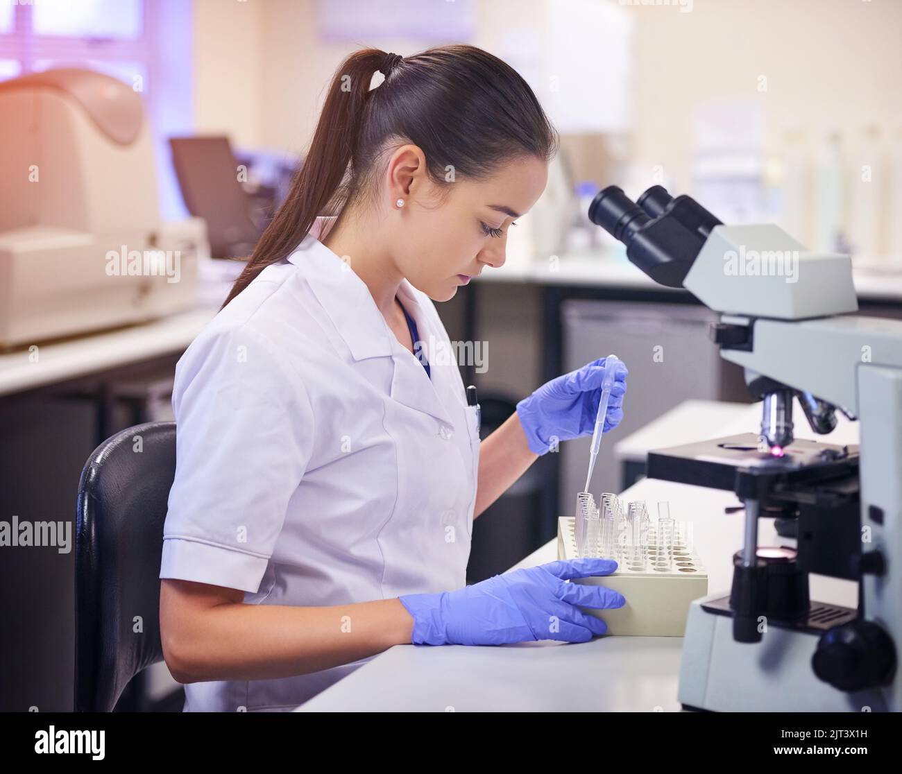 Processing specimens like a pro. a young scientist transferring liquid ...