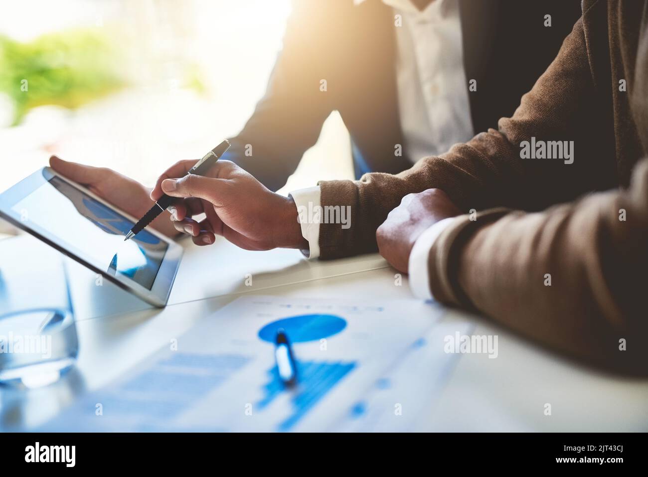 Expanding on their business potential together. Closeup shot of two unidentifiable businessmen working together on a digital tablet in an office. Stock Photo