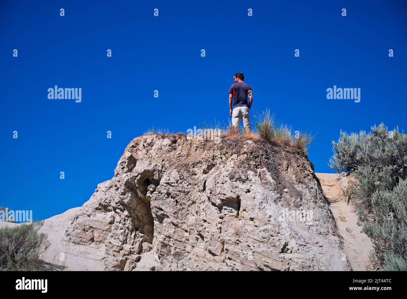 Low angle view of mature man standing on the rock Stock Photo